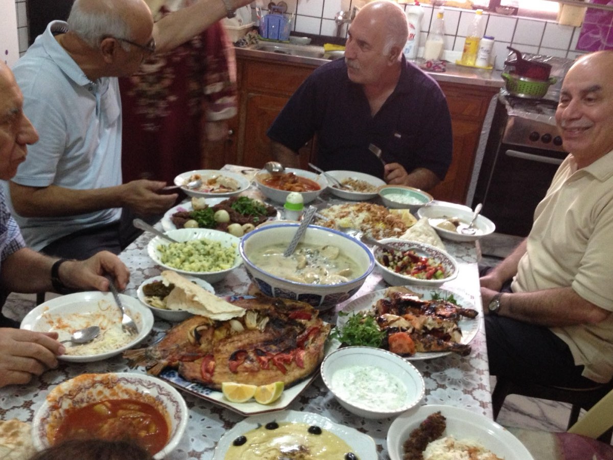 One of the usual banquets during my visits, this time at my sister Sawsan's home: a heated discussion over a feast of Masgouf fish and kebab between my brother Amer and my cousin Salah (my sister's husband).